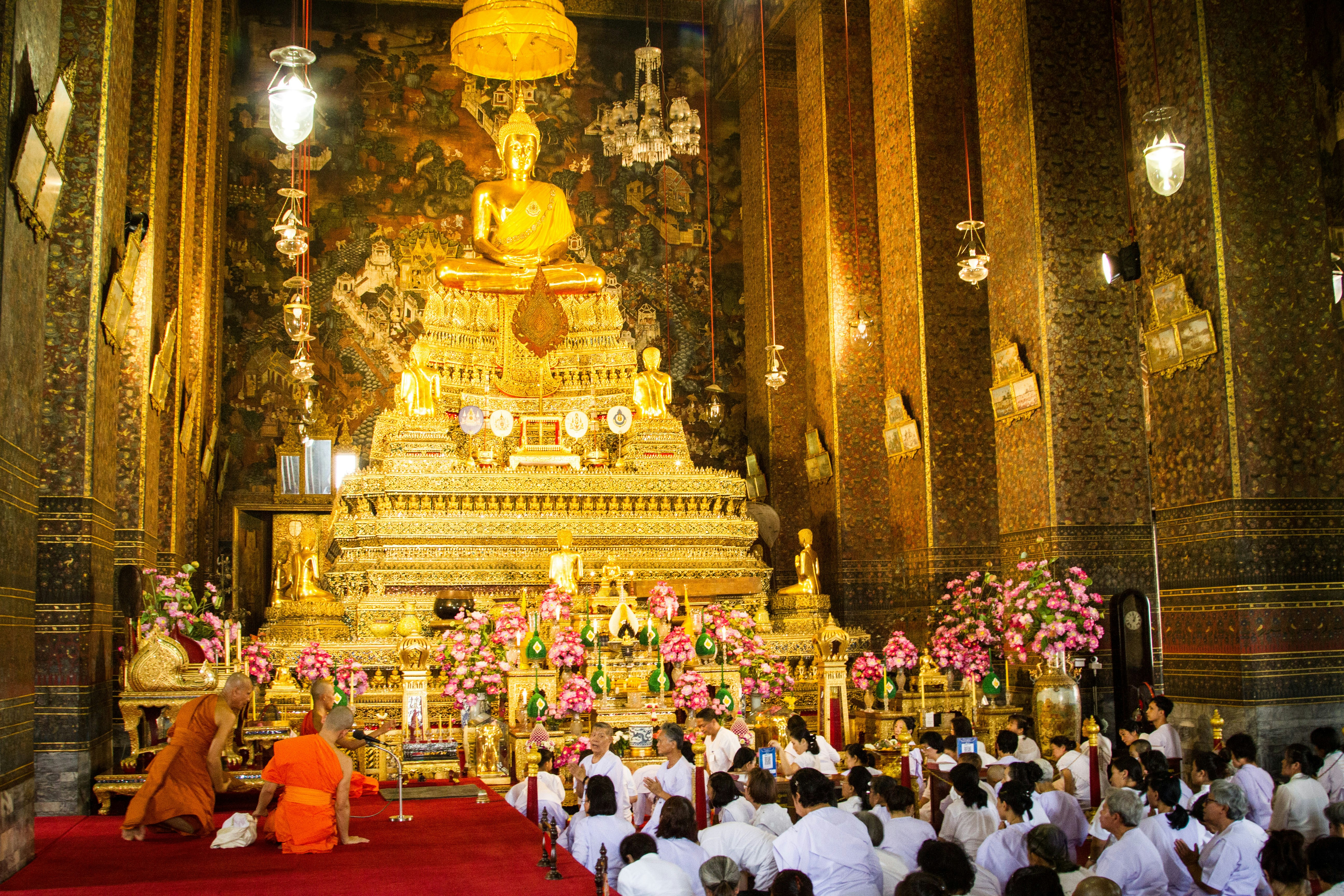 people in white shirt standing near gold temple during daytime